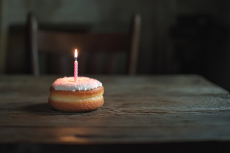 Photo of a small birthday cake with pink candles on top, sitting alone on an old wooden table. Web banner with copy space on the right. --ar 3:2 --v 6.1 Job ID: 96241747-8bc9-44ff-8ce6-bf3885e6d3a3の素材