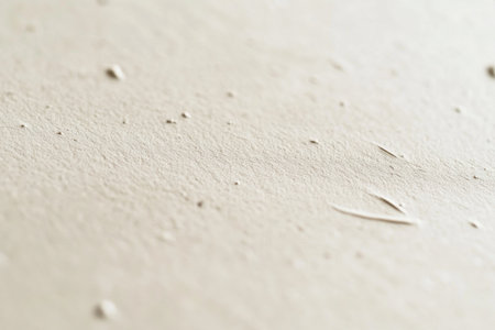 A close-up of the texture on light beige kraft paper, emphasizing its natural and soft appearance with subtle ink marks scattered across it. The background is plain white to highlight the intricate details in the paper's surface. --ar 3:2 --v 6.1 Job ID: 2043fa75-ec02-4b8b-8ff9-dd6cd7266795の素材