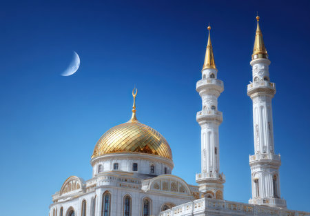 A grand structure featuring a golden dome and towering minarets is depicted against a vivid blue sky with a crescent moon. The building's white facade contrasts with the gold accents, creating a visually striking composition. This image may be suitable for architectural, cultural, or travel related content.の素材