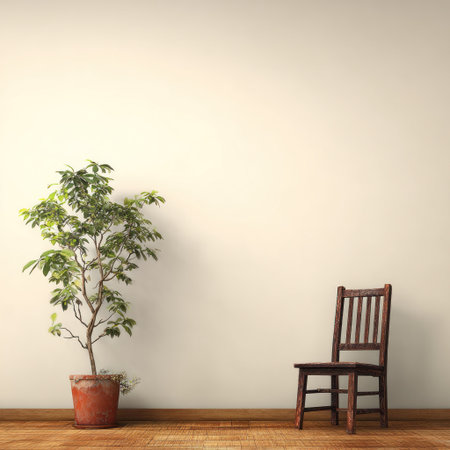 A potted plant with lush green leaves stands next to a wooden chair in a room. The composition is simple, featuring a neutral wall and wooden floor. Soft lighting creates subtle shadows. This image could be used for illustrating concepts of home decor, design, and minimalist lifestyles in a variety of commercial contexts.の素材
