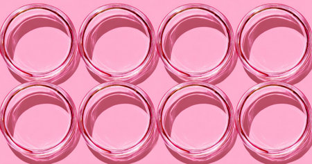 Eight transparent circular objects on a pink background with defined shadowsの素材