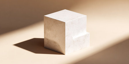 A textured, stepped cube casts a shadow on a neutral beige background under directional lightの素材