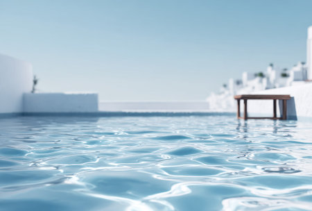 A shallow pool with rippling water reflecting a bright blue sky. White buildings in the blurred backgroundの素材