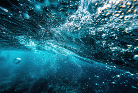 Underwater view of swirling water, bubbles, and light refracting through, creating a blue ambianceの素材