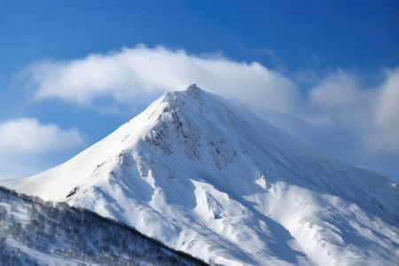 snow-covered mountain peak with clear blue sky and clouds visible above, created with generative aiの素材