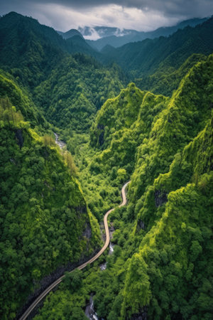aerial view of a winding mountain trail through lush forest, created with generative aiの素材
