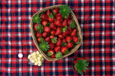 top view of a checkered picnic blanket with strawberries, created with generative aiの素材