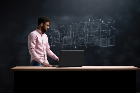 cropped shot of a man using his laptop while standing in front of a blackboard, created with generative aiの素材