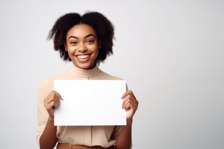 shot of an attractive young woman holding a blank placard and smiling at the camera, created with generative aiの素材