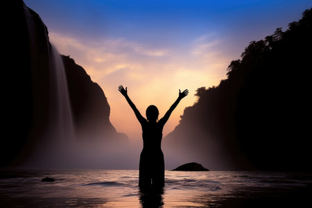 silhouette of a standing woman with her arms raised by an idyllic waterfall, created with generative aiの素材