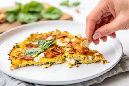 hand serving a slice of cauliflower pizza onto a white plate, created with generative aiの素材