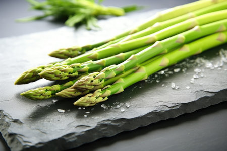 crisp asparagus spears lying on a smooth stone slab, created with generative aiの素材