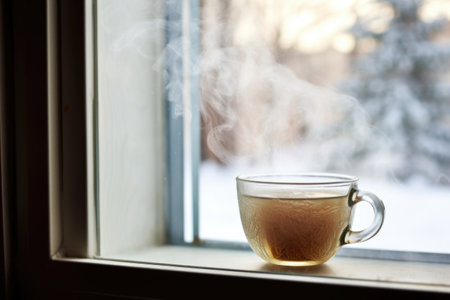 steaming herbal tea in a clear teacup on a frosty window ledge, created with generative aiの素材