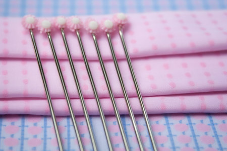 a row of diaper pins on a blue or pink pastel cloth, created with generative aiの素材