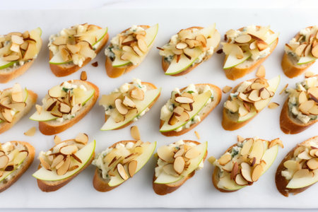 a neatly arranged row of apple gorgonzola bruschettas on a white linen tablecloth, created with generative aiの素材