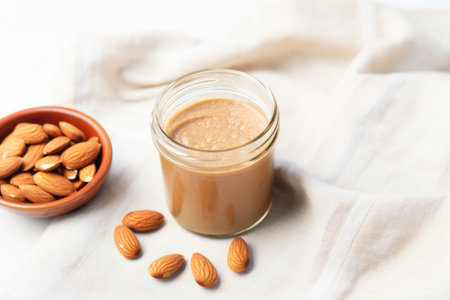 toast with almond butter next to a jar on a linen cloth, created with generative aiの素材
