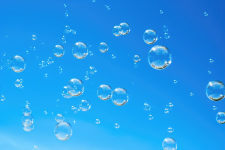 multiple bubbles floating against a clear blue sky, created with generative aiの素材