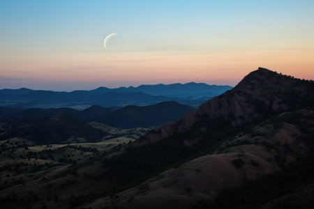 crescent moon between two hill peaks, created with generative aiの素材