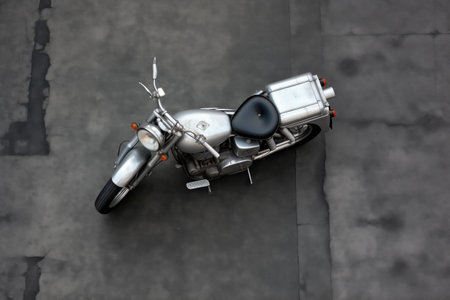 a silver vintage motorcycle from above on a gray pavement, created with generative aiの素材