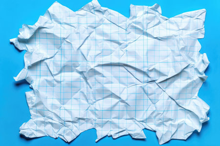 crumpled grid paper against a blue background, created with generative aiの素材