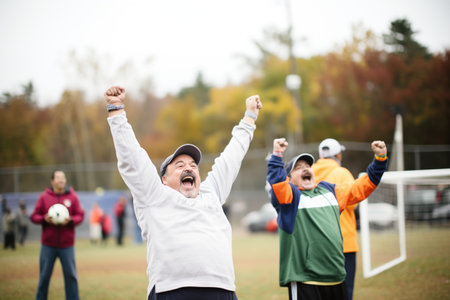 two fathers cheering at their childs soccer gameの素材
