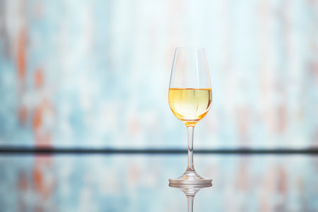 white wine glass with reflection on shiny surfaceの素材