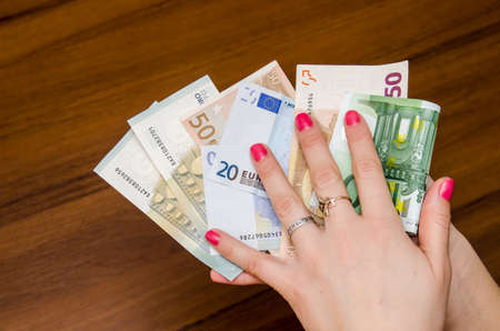 Woman holding different euro banknotes