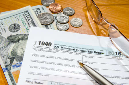 deadline time of 1040 tax form for 2016 with dollar and pen