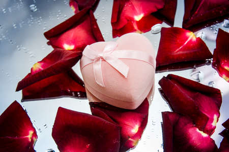 pink gift box and red rose petalsの写真素材