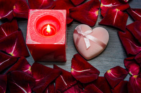 candle, red petal rose with gift box on table. valentine concept background