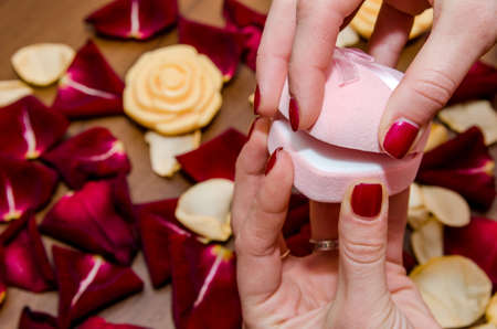 woman hands holding red box against red petals rosesの写真素材
