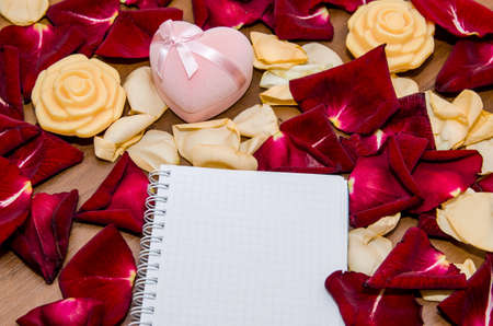 valentines day - empty notepad and gift box with many rose petals. Top viewの写真素材