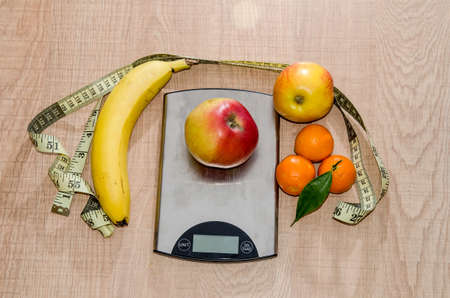 Concept of diet. Low-calorie fruit over measuring weightの写真素材