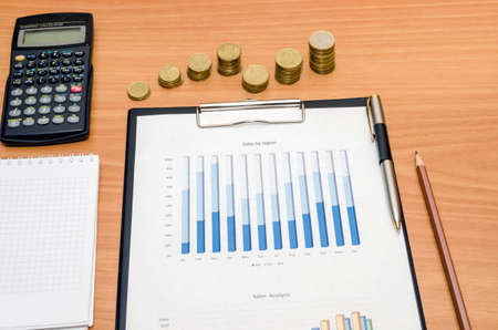 business diagram with coins, pen and calculator on tableの写真素材