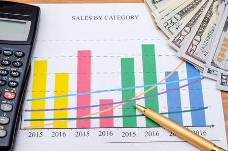 business graph with usa dollar, calculator, penの写真素材