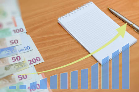 euro banknote with arrow on wooden tableの写真素材