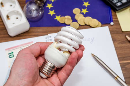 Light bulb in hand, calculator and usa dollar and coinsの写真素材