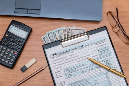 tax form with computer on tableの写真素材