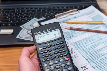 tax form with money and copmuterの写真素材