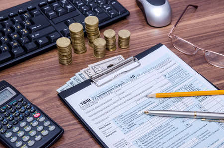 tax form with money and copmuter