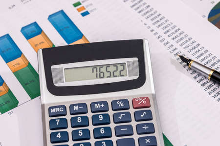 business chart with calculator and pen.
