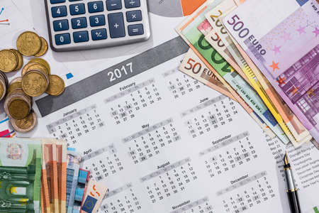 2017 calendar, pen, euros bills and calculator placed on a table.の写真素材