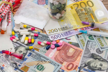 different pills on dollar and euro bills.の写真素材