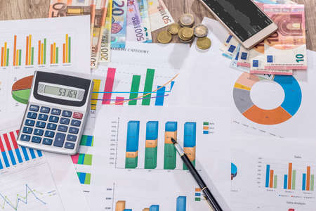 Financial close-up background. Financial accounting graphs, euro, pen, phone and calculator.