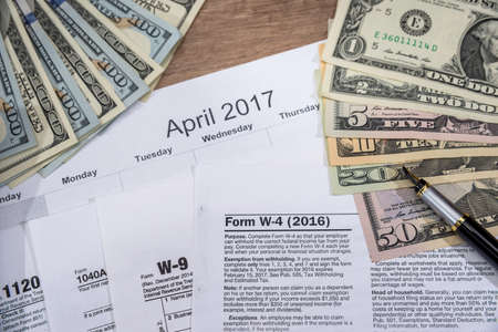 w4, w9 tax form with money on desk.