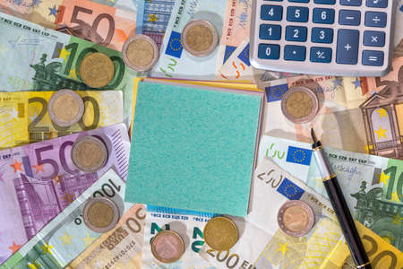 empty blank with euro bills, coin and calculator on desk.の写真素材