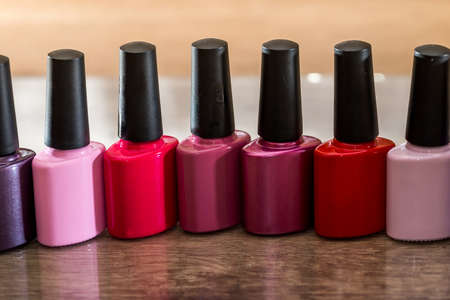 Group of bright nail polishes on wooden desk.の写真素材
