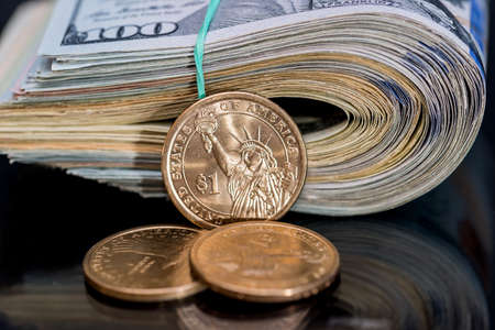 us roll dollar with coin isolated on black.