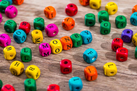 Word "money" of the colored wooden cubes on wooden desk.の写真素材