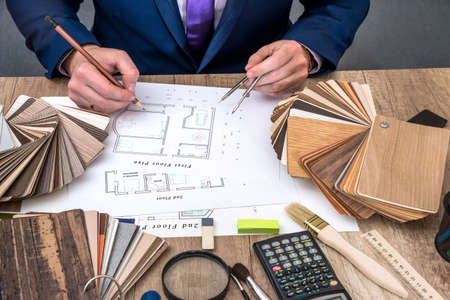 designer working with architect sketching construction project on wooden tableの写真素材